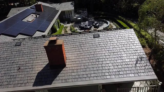 Synthetic slate tiles around a brick chimney