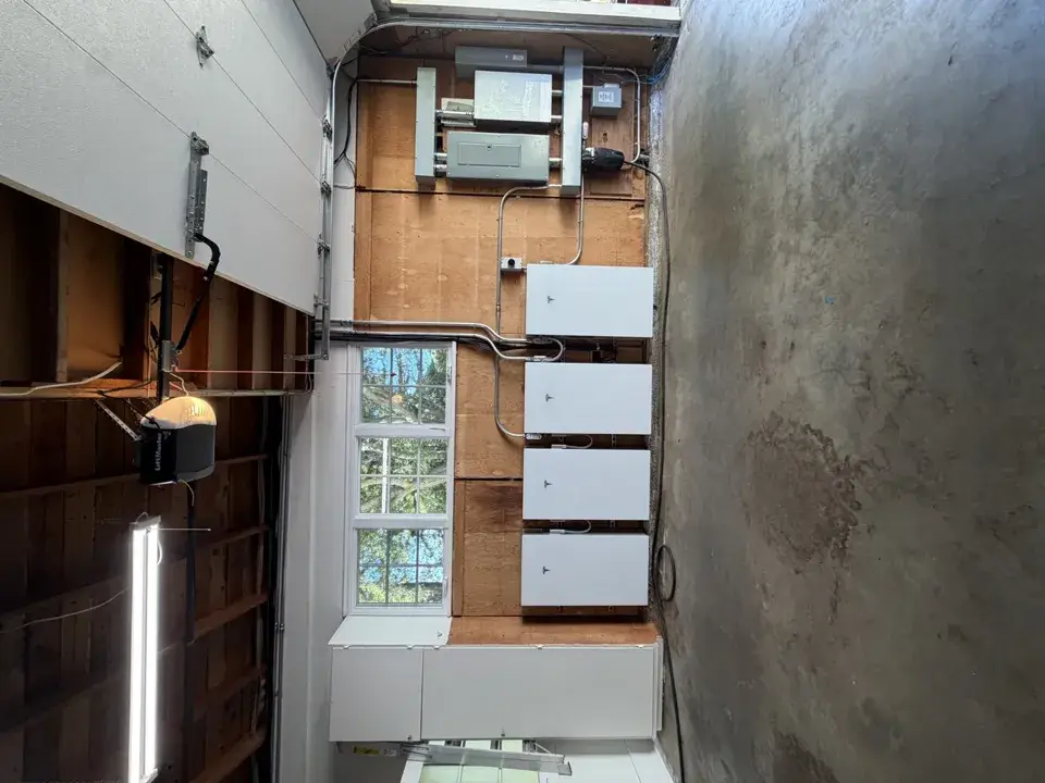 Four wall-mounted home batteries installed by Spartan in a clean garage