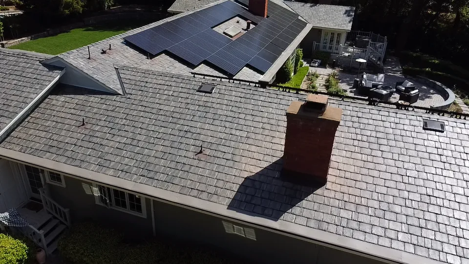 DECRA stone-coated steel roof with solar panels and a brick chimney