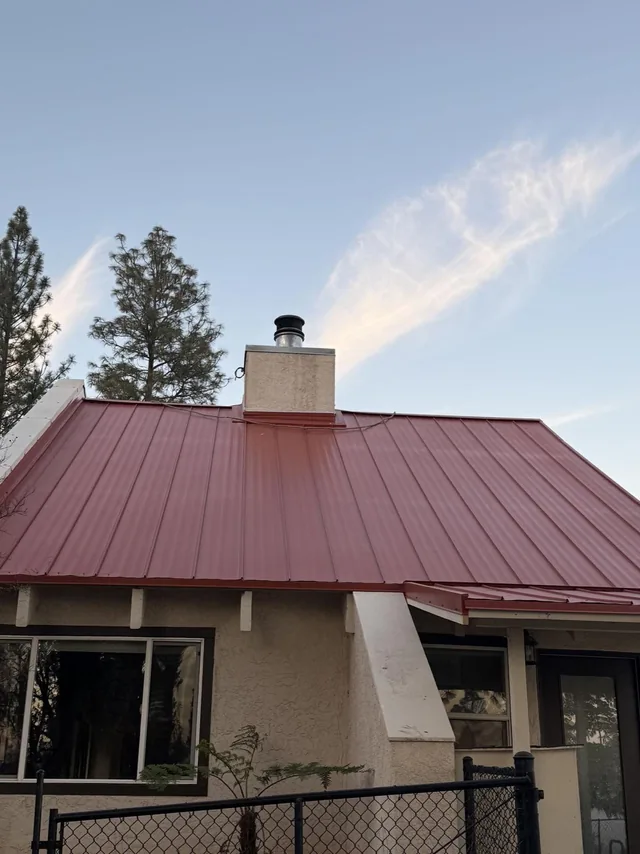 Finished red standing seam roof above the front of a home